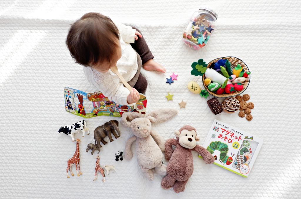 Baby playing with toys dolls and books